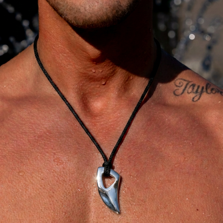Mann trägt Shark Tooth Anhänger aus 316L Edelstahl von ETERNAL an schwarzer Kordel